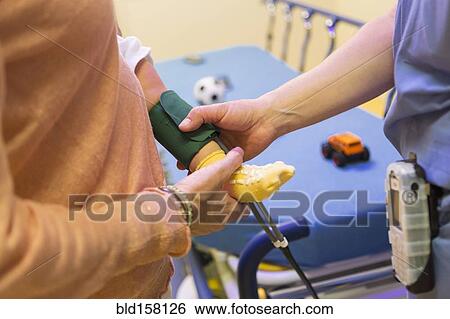 Stock Photograph - Doctor measuring blood pressure on leg of baby boy. Fotosearch