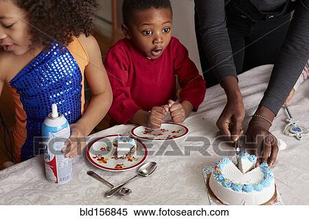 Stock Photography - Excited children anticipating cake at party. Fotosearch