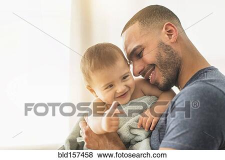 Stock Photo - Father drying baby son with towel after bath. Fotosearch