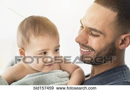 Stock Photo - Father drying baby son with towel after bath. Fotosearch