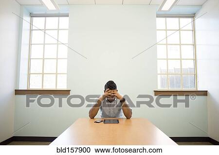 Stock Image - Frustrated Asian businessman using digital tablet in office. Fotosearch