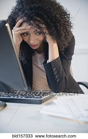 Frustrated mixed race businesswoman working at computer in office View Large Photo Image Stock Image - Frustrated mixed race businesswoman working at computer in office. Fotosearch