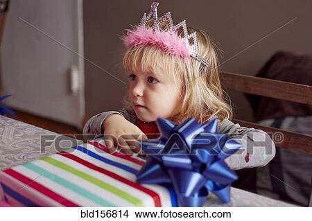 Girl wearing tiara and holding gift View Large Photo Image Picture - Girl wearing tiara and holding gift. Fotosearch