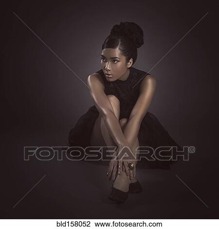 Stock Image - Glamorous woman sitting on floor. Fotosearch