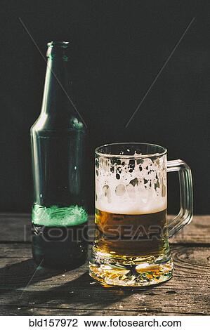 Stock Image - Glass and bottle of beer on table. Fotosearch