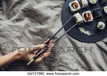 Hand of woman reaching for platter of sushi on bed View Large Photo Image Stock Photography - Hand of woman reaching for platter of sushi on bed. Fotosearch
