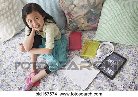 High angle view of Chinese girl doing homework on bed View Large Photo Image Picture - High angle view of Chinese girl doing homework on bed. Fotosearch
