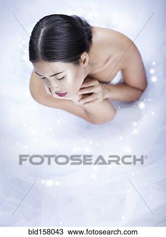 Stock Image - High angle view of glamorous woman wearing white gown. Fotosearch