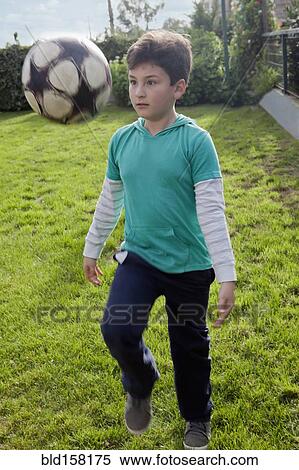 Hispanic boy juggling soccer ball in backyard View Large Photo Image Stock Photography - Hispanic boy juggling soccer ball in backyard. Fotosearch