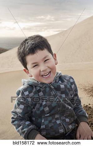 Hispanic boy smiling on sand dune on beach View Large Photo Image Stock Image - Hispanic boy smiling on sand dune on beach. Fotosearch