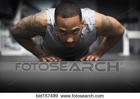 Hispanic man doing push-ups in gym View Large Photo Image Stock Photo - Hispanic man doing push-ups in gym. Fotosearch