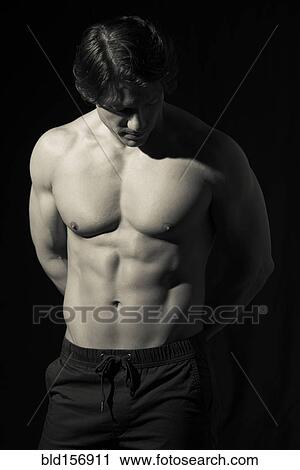 Stock Image - Hispanic man with bare chest looking down. Fotosearch