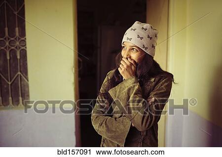 Stock Image - Laughing woman covering her mouth. Fotosearch