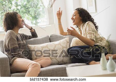 Laughing women relaxing on sofa View Large Photo Image Stock Photo - Laughing women relaxing on sofa. Fotosearch