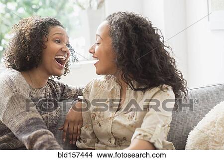 Laughing women talking on sofa View Large Photo Image Picture - Laughing women talking on sofa. Fotosearch