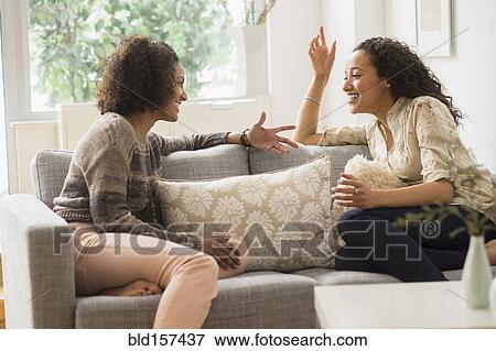 Laughing women talking on sofa View Large Photo Image Stock Photo - Laughing women talking on sofa. Fotosearch