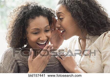 Stock Image - Laughing women whispering secrets. Fotosearch