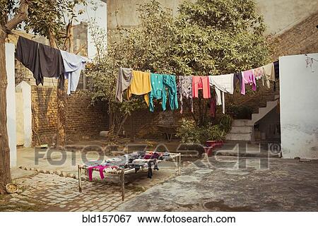 Laundry drying on clothesline in backyard View Large Photo Image Stock Photo - Laundry drying on clothesline in backyard. Fotosearch