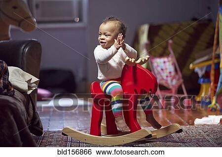 Mixed race baby girl playing on rocking horse View Large Photo Image Stock Photograph - Mixed race baby girl playing on rocking horse. Fotosearch