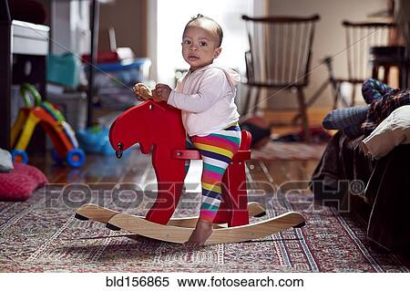 Mixed race baby girl playing on rocking horse View Large Photo Image Stock Photography - Mixed race baby girl playing on rocking horse. Fotosearch