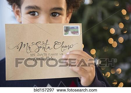 Mixed race boy holding letter to Santa for Christmas View Large Photo Image Stock Photo - Mixed race boy holding letter to Santa for Christmas. Fotosearch
