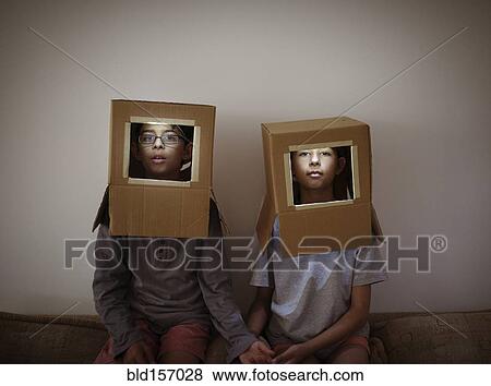 Stock Photo - Mixed race brother and sister wearing cardboard box astronaut helmets. Fotosearch