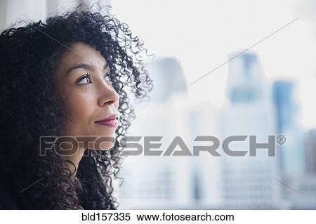 Mixed race businesswoman looking out window View Large Photo Image Stock Photography - Mixed race businesswoman looking out window. Fotosearch