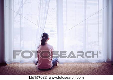 Mixed race girl sitting on floor near window View Large Photo Image Stock Image - Mixed race girl sitting on floor near window. Fotosearch