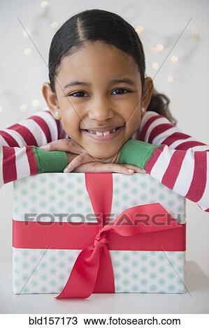 Mixed race girl smiling with wrapped gift View Large Photo Image Stock Image - Mixed race girl smiling with wrapped gift. Fotosearch