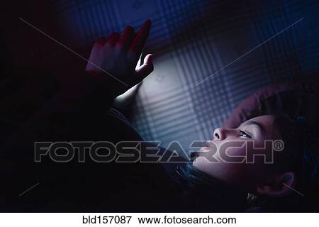 Mixed race girl using cell phone at night View Large Photo Image Stock Photo - Mixed race girl using cell phone at night. Fotosearch