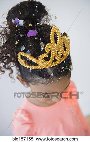 Stock Photography - Mixed race girl wearing tiara and confetti. Fotosearch