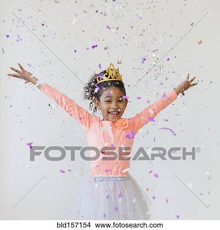 Picture - Mixed race girl wearing tiara throwing confetti. Fotosearch