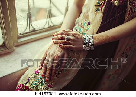Stock Image - Mixed race girl with henna tattoos on hands. Fotosearch