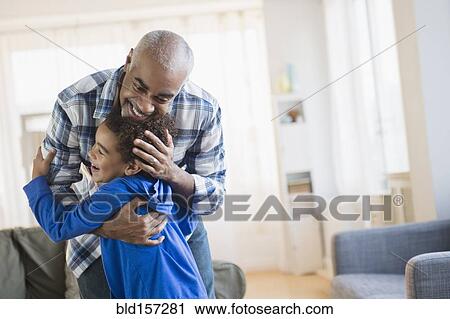 Mixed race grandfather and grandson hugging in living room View Large Photo Image Stock Image - Mixed race grandfather and grandson hugging in living room. Fotosearch
