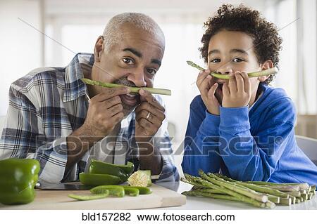 Mixed race grandfather and grandson making mustaches with asparagus View Large Photo Image Stock Image - Mixed race grandfather and grandson making mustaches with asparagus. Fotosearch