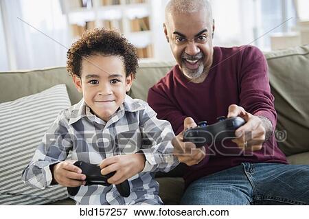 Stock Photo - Mixed race grandfather and grandson playing video games. Fotosearch