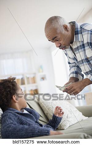 Mixed race grandfather giving money to grandson View Large Photo Image Stock Photography - Mixed race grandfather giving money to grandson. Fotosearch