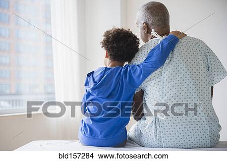 Mixed race grandfather sitting with grandson in hospital View Large Photo Image Picture - Mixed race grandfather sitting with grandson in hospital. Fotosearch