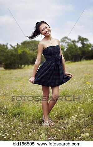Mixed race teenage girl smiling in field View Large Photo Image Stock Photography - Mixed race teenage girl smiling in field. Fotosearch