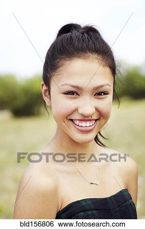 Stock Photograph - Mixed race teenage girl smiling outdoors. Fotosearch