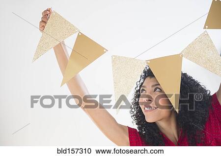 Mixed race woman hanging celebration banner View Large Photo Image Stock Image - Mixed race woman hanging celebration banner. Fotosearch