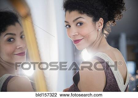 Mixed race woman wearing evening gown near mirror View Large Photo Image Stock Image - Mixed race woman wearing evening gown near mirror. Fotosearch