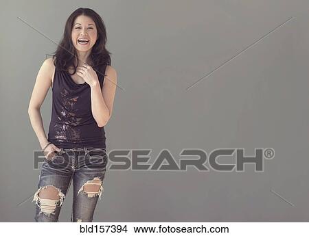 Mixed race woman wearing ripped jeans View Large Photo Image Picture - Mixed race woman wearing ripped jeans. Fotosearch