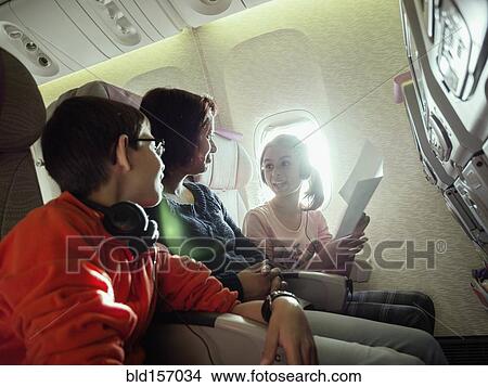 Picture - Mother and children talking in airplane. Fotosearch