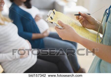 Nurse marking medical chart near pregnant women View Large Photo Image Stock Image - Nurse marking medical chart near pregnant women. Fotosearch