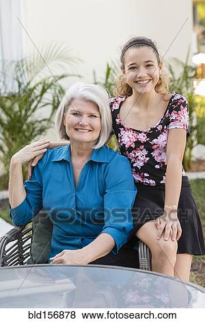 Older grandmother and granddaughter smiling in backyard View Large Photo Image Stock Photo - Older grandmother and granddaughter smiling in backyard. Fotosearch