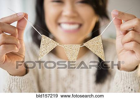 Stock Photo - Pacific Islander woman holding miniature banner decoration. Fotosearch
