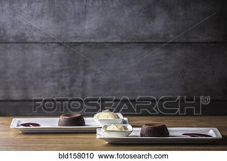 Platters of chocolate souffle dessert with ice cream and sauce View Large Photo Image Stock Image - Platters of chocolate souffle dessert with ice cream and sauce. Fotosearch
