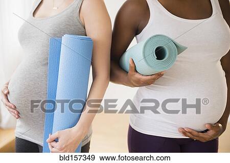 Pregnant women carrying yoga mats View Large Photo Image Stock Photo - Pregnant women carrying yoga mats. Fotosearch
