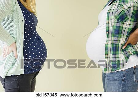 Pregnant women displaying profile of midsections View Large Photo Image Stock Photography - Pregnant women displaying profile of midsections. Fotosearch